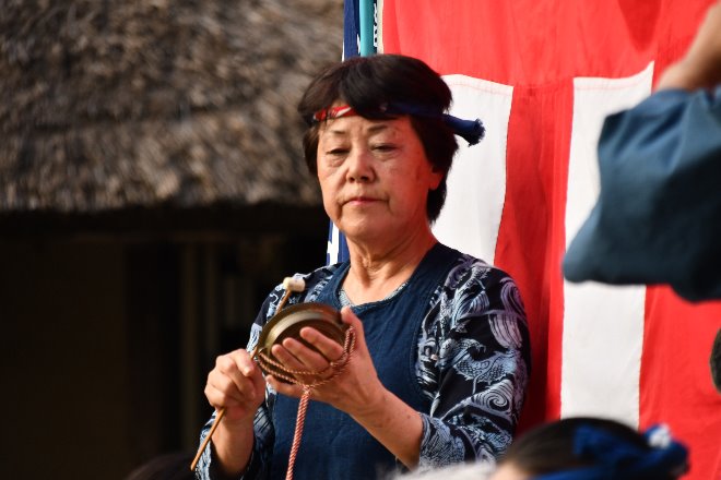 かねを演奏する女性の写真