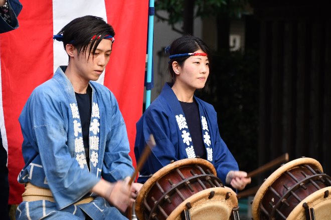 男女二人がそれぞれ締め太鼓を演奏している写真